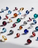 A variety of colored gems are arranged on a white surface photo