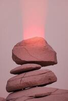 A stack of rocks with a red light shining on top photo