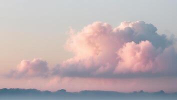 A pink cloud is seen in the sky over a lake photo