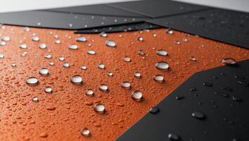 A close up of a black and orange surface with water droplets photo