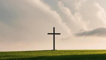 A cross stands in a field with a cloudy sky photo