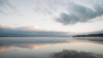 A lake with mist and clouds reflected in the water photo