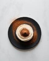A dessert on a black plate with a white background photo