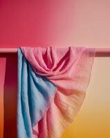 A pink and blue scarf hanging on a pole photo