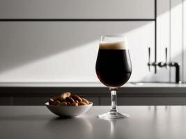 A glass of beer and a bowl of nuts on a counter photo
