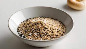 A bowl of sesame seeds and a garlic clove photo