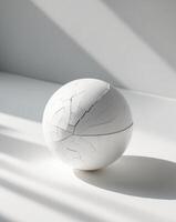 A white ball sitting on a table with a crack in it photo