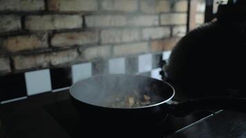 Chef sautes mushrooms with flames in restaurant while flipping around food. Professional cooking. video