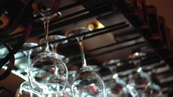 Clean wine glasses prepared by bartender and hung on the bar at a restaurant or cafe. Glasses prepared for a party at the bar. video