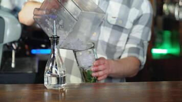 Barman adding an ice into the cocktail glass with a cane sugar and lime for making a delicious cocktail video