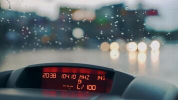 Raindrops fall on the windshield of the car. Inside view. Car dashboard. Close-up video