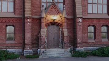 A red brick building with a door and a clock photo