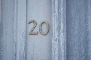 A weathered, rustic wooden door showcasing the number 20 in a charming and decorative style photo
