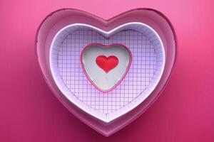 Vibrant and Colorful HeartShaped Decorative Boxes Displayed on a Soft Pink Background photo