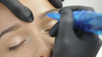 Permanent Tattooing Of Eyebrows. Cosmetologist applying permanent make up on eyebrows video