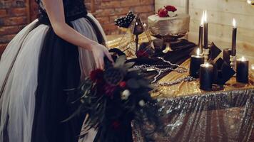 Witch sitting by the table. Portrait of young witch woman sitting at table in room video