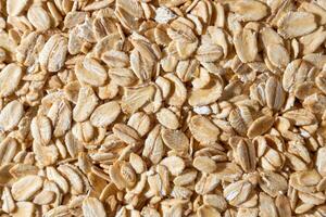 Uncooked Oat Flakes background - Top View, Flat Lay. Scattered Dry and Raw Oat Flakes. Healthy Breakfast and Diet Eating Ingredients photo