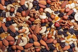 Mixed Nuts. Almonds, Walnuts, Cashews, Peanuts, Hazelnuts, Dried Prunes and Raisins. Different Nut Mix. Background from Various Nuts and Dried Fruits photo