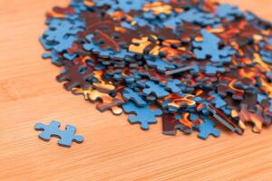 Colorful Pieces of a Mixed Jigsaw Puzzle Lie on the Wooden Table - Strategy and Solving Problem Concept photo