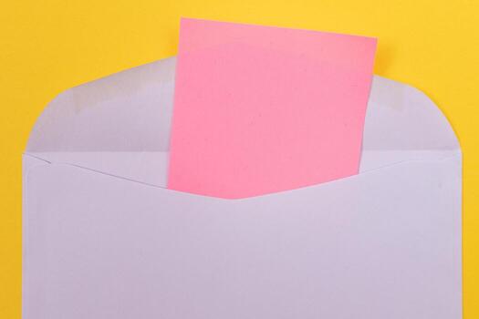 Violet Envelope with Blank Pink Sheet of Paper Inside, Lying on Yellow Background - Mock Up with Copy Space. Receiving Mail or Notice, Sending Postcard - Top View, Flat Lay photo