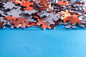 Mixed Pieces of a Colorful Jigsaw Puzzle Lie on the Blue Background With Copy Space - Strategy and Solving Problem Concept photo