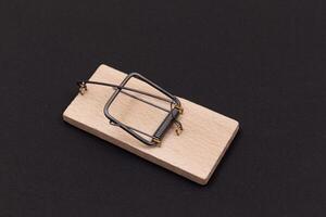 Wooden Mouse Trap. Empty Loaded Mousetrap on Black Background photo