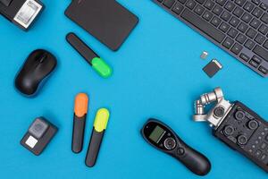 Top View of Photographer's, Videographer's or Blogger's Workplace. Digital Gadgets Lying on Blue Table - Flat Lay photo