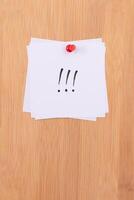 White Sticky Notes with Three Exclamation Points Pinned to the Wooden Message Board. To Do List Reminder in the Office. Memo Note at Work photo