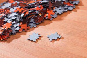 Colorful Pieces of a Mixed Jigsaw Puzzle Lie on the Wooden Table - Strategy and Solving Problem Concept photo