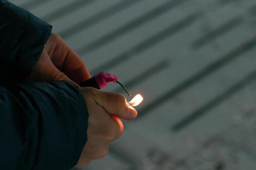 Burning Firecracker with Sparks. Guy Holding a Petard in a Hand. Loud and Dangerous New Year's Entertainment. Hooliganism with Pyrotechnics. Noise of Firecrackers in Public Places photo