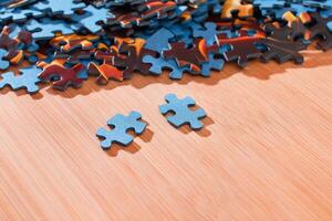 Colorful Pieces of a Mixed Jigsaw Puzzle Lie on the Wooden Table - Strategy and Solving Problem Concept photo