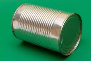 Unopened Tin Can with Blank Edge on Green Background. Canned Food. Aluminum Can for Safe and Long Term Storage of Food. Steel Sealed Food Storage Container photo