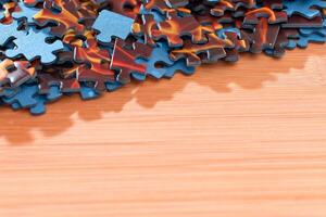 Colorful Pieces of a Mixed Jigsaw Puzzle Lie on the Wooden Table - Strategy and Solving Problem Concept photo