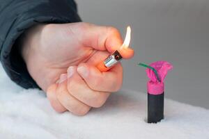 Guy Sets Fire to the Flash Noise Firecracker Outdoors in Winter at Daytime. Loud and Dangerous New Year's Entertainment. Hooliganism with Pyrotechnics. Noise of Petards in Public Places photo
