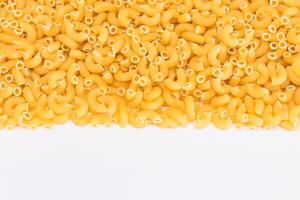 Uncooked Chifferi Rigati Pasta Scattered on White Table. Fat and Unhealthy Food. Classic Dry Macaroni. Italian Culture and Cuisine. Raw Pasta photo