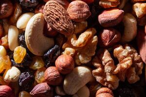 Mixed Nuts. Almonds, Walnuts, Cashews, Peanuts, Hazelnuts, Dried Prunes and Raisins. Different Nut Mix. Background from Various Nuts and Dried Fruits photo