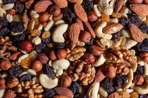 Mixed Nuts. Almonds, Walnuts, Cashews, Peanuts, Hazelnuts, Dried Prunes and Raisins. Different Nut Mix. Background from Various Nuts and Dried Fruits photo