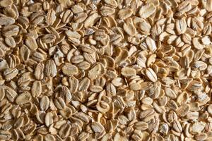 Uncooked Oat Flakes background - Top View, Flat Lay. Scattered Dry and Raw Oat Flakes. Healthy Breakfast and Diet Eating Ingredients photo