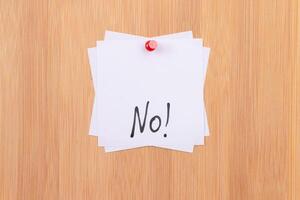 NO - White Sticky Notes with Written Word NO, Pinned to the Wooden Message Board. To Do List Reminder in the Office. Memo Note at Work photo