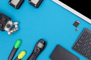 Top View of Photographer's, Videographer's or Blogger's Workplace. Digital Gadgets Lying on Blue Table - Flat Lay photo