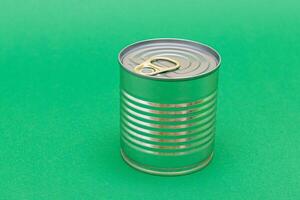 Unopened Tin Can with Blank Edge on Green Background. Canned Food. Aluminum Can for Safe and Long Term Storage of Food. Steel Sealed Food Storage Container photo