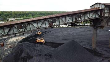 Tracor raking coal. Moving tractor coal around plant for processing video
