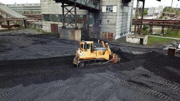 Coal mining industry. Yellow tractor loading the coal in construction site video