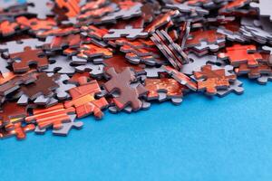 Mixed Pieces of a Colorful Jigsaw Puzzle Lie on the Blue Background - Strategy and Solving Problem Concept photo