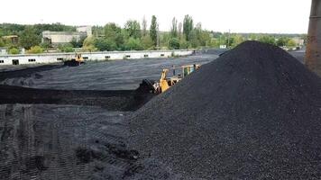 Coal mining industry. Yellow tractor loading the coal in construction site video