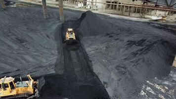 Tracor raking coal. Moving tractor coal around plant for processing video