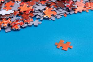 Mixed Pieces of a Colorful Jigsaw Puzzle Lie on the Blue Background - Strategy and Solving Problem Concept photo