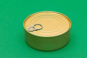 Unopened Tin Can with Blank Edge on Green Background. Canned Food. Aluminum Can for Safe and Long Term Storage of Food. Steel Sealed Food Storage Container photo