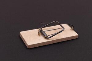 Wooden Mouse Trap. Empty Loaded Mousetrap on Black Background photo