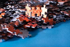 Mixed Pieces of a Colorful Jigsaw Puzzle Lie on the Blue Background - Strategy and Solving Problem Concept photo